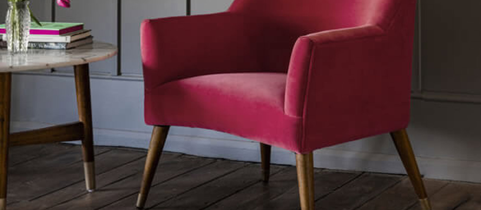 Hot pink armchair in a darkly decorated room