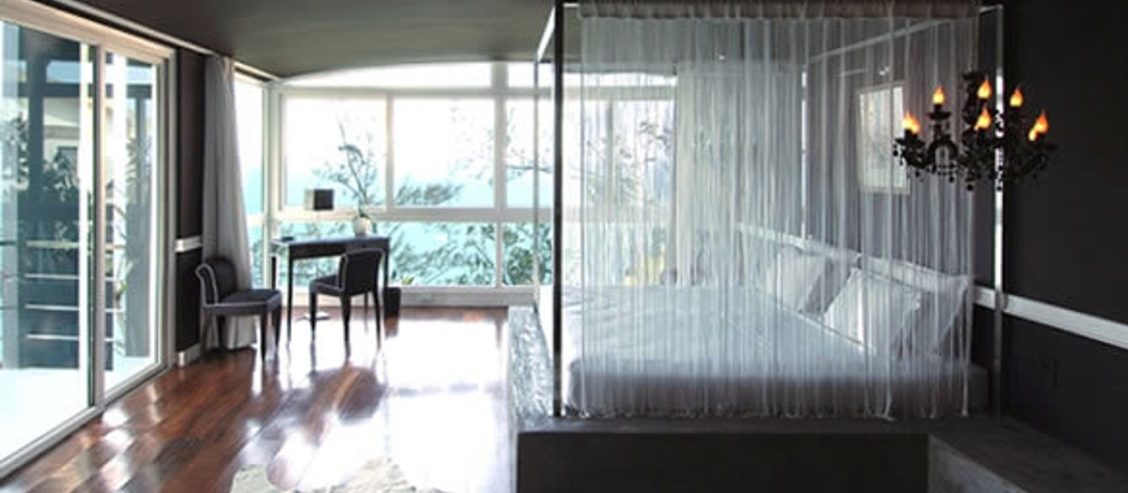 Modern cosy bedroom with luxurious voile curtains around the bed