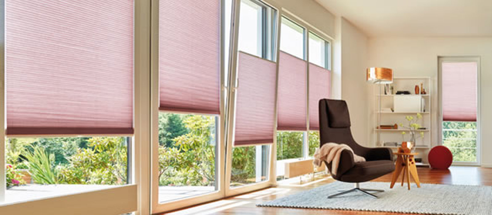 Modern living room with large tilt windows fitted with pink Duette energy saving blinds
