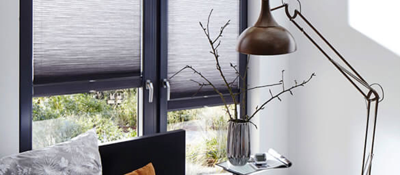 Modern bedroom with full length windows fitted with Duette energy-saving blinds